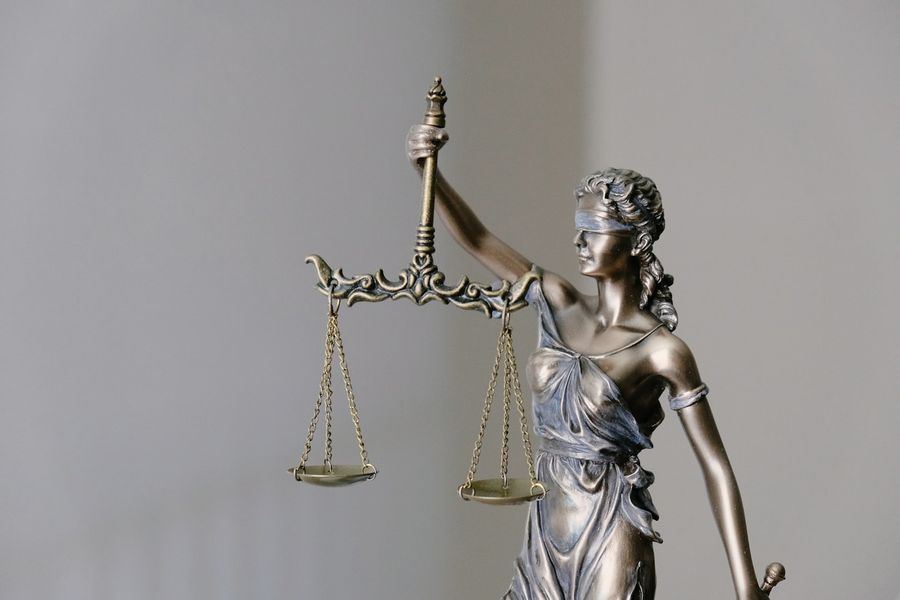 Estátua da justiça com balança e espada simbolizando responsabilidade profissional